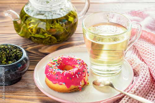 Cup of hot green tea beverages with donut glazed