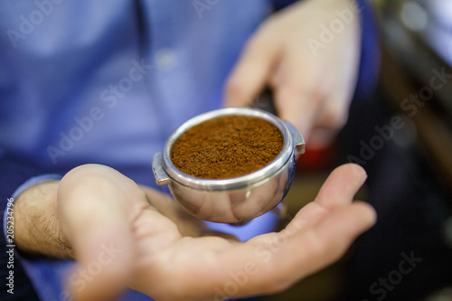 Photo of barista man with mortar with coffee