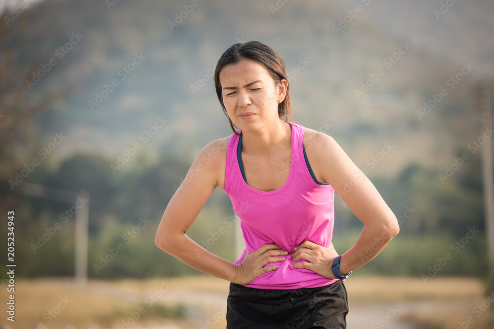 sport woman stomachache in a park in summer sport woman stomachache in a park in summer