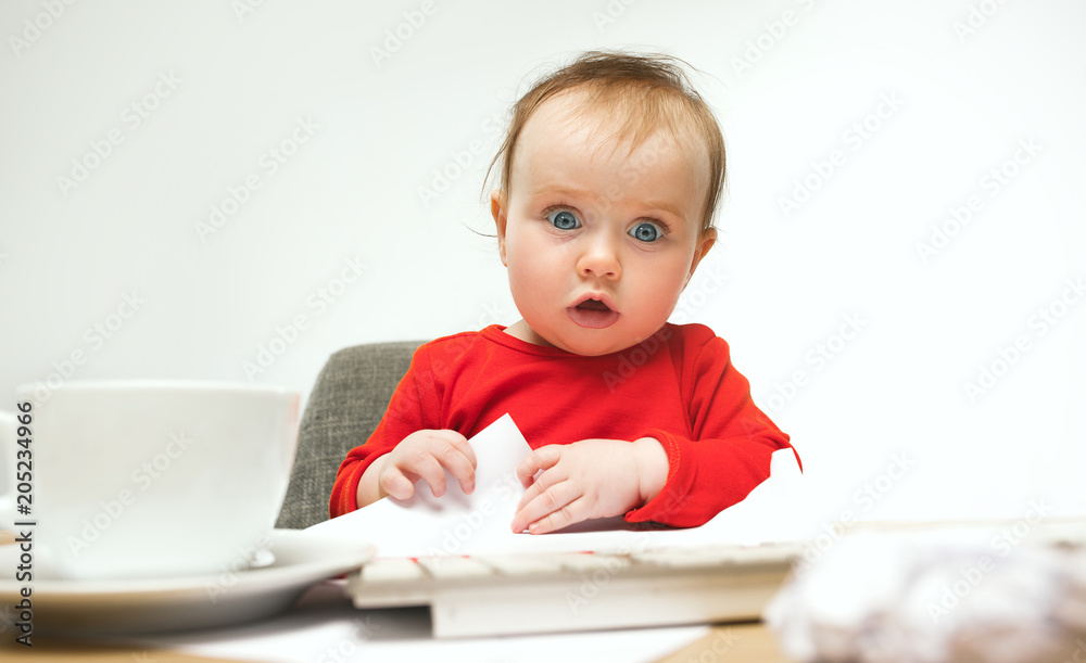 Happy child baby girl toddler sitting with keyboard of computer isolated on a white background Happy child baby girl toddler sitting with keyboard of computer isolated on a white background