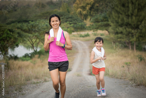 mother and her daughter running on the road in the countryside, sports, healthy lifestyle