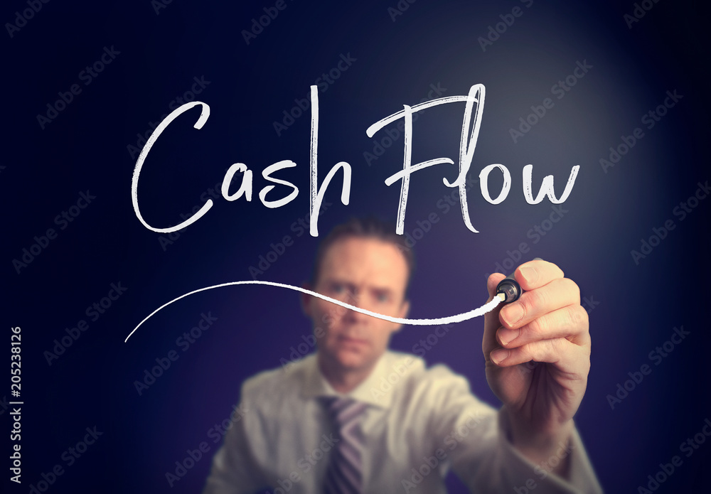 A businessman writing a Cash Flow concept with a white pen on a clear screen. A businessman writing a Cash Flow concept with a white pen on a clear screen.