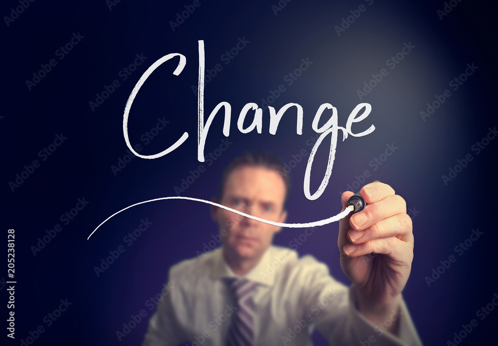 A businessman writing a Change concept with a white pen on a clear screen. A businessman writing a Change concept with a white pen on a clear screen.