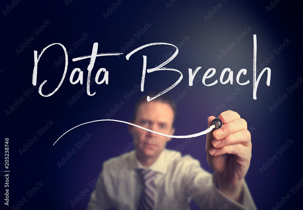 A businessman writing a Data Breach concept with a white pen on a clear screen. A businessman writing a Data Breach concept with a white pen on a clear screen.