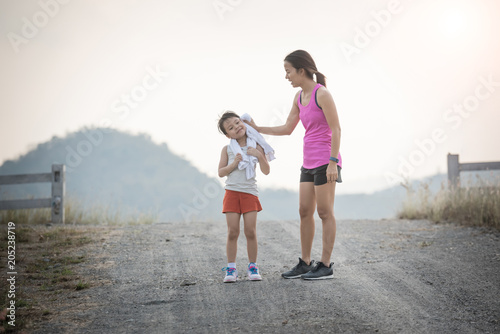 mother and her daughter running on the road in the countryside, sports, healthy lifestyle © nareekarn