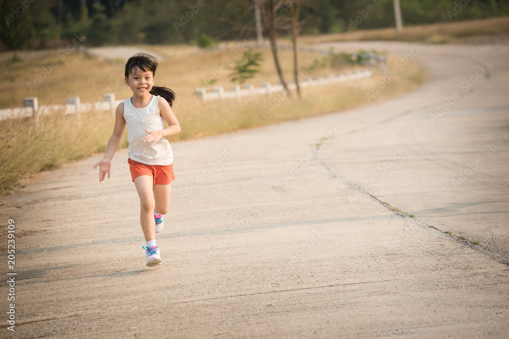 Little girl running running on the road in the countryside, sports, healthy lifestyle Little girl running running on the road in the countryside, sports, healthy lifestyle