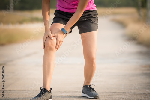 woman runner hold her sports injured knee