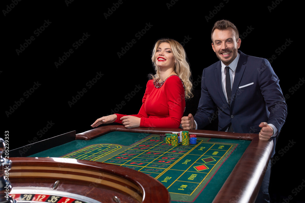 Beautiful and well dressed couple playing roulette in the casino Beautiful and well dressed couple playing roulette in the casino