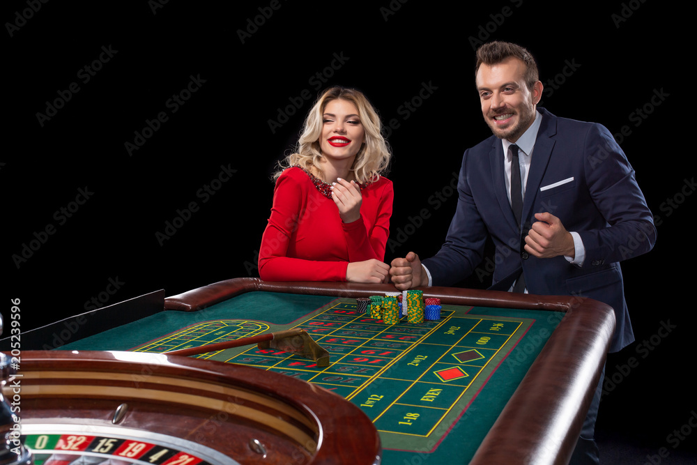 Beautiful and well dressed couple playing roulette in the casino Beautiful and well dressed couple playing roulette in the casino