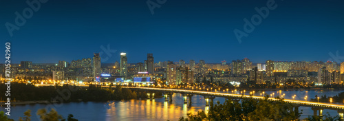 Panorama of Kiev city at night. Kyiv Left bank skyline with Paton bridge over Dnieper river