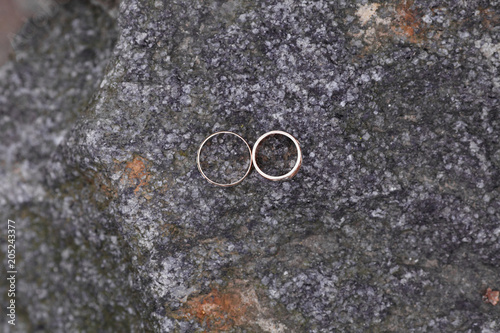 Wedding rings close-up against stone texture background. Concept of holiday creating family