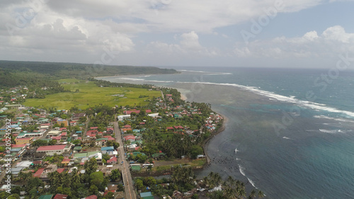 Aerial view of seashore with coastal town, beach, lagoons and coral reefs. Bulusan, Philippines, Luzon. Ocean coastline with turquoise water. Tropical landscape in Asia.