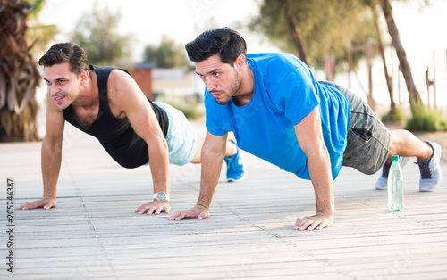 Two friends 30 years old are doing push-ups for endurance