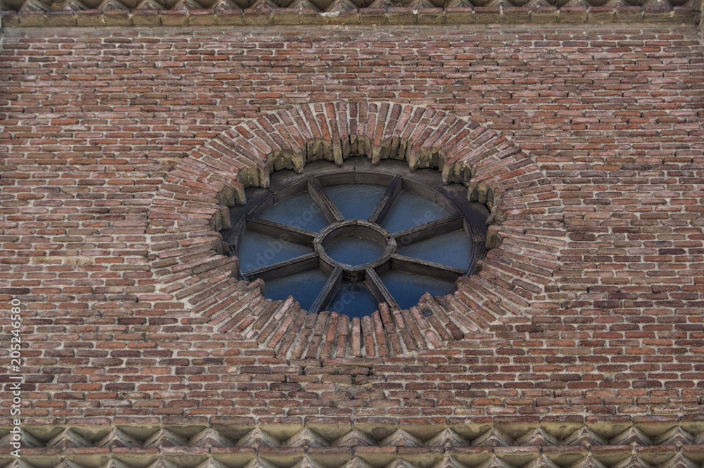 Rosetón / rose window of wood and glass in a brick facade of a church in Madrid. Spain