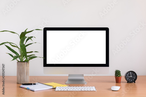 All in one computer, mouse, keyboard, note book, pen, cactus and tree vase on wooden table