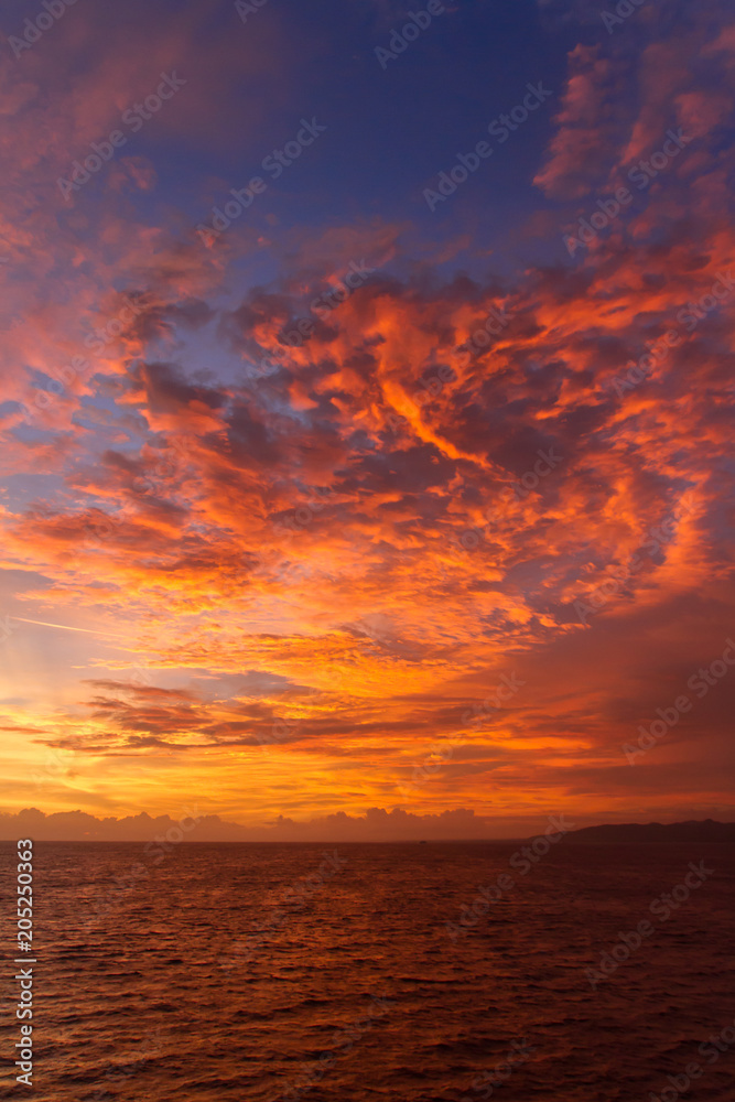 summer sunset colorful sky with dramatic  purple red and yellow clouds over picturesque water landscape. Bali, Indonesia.