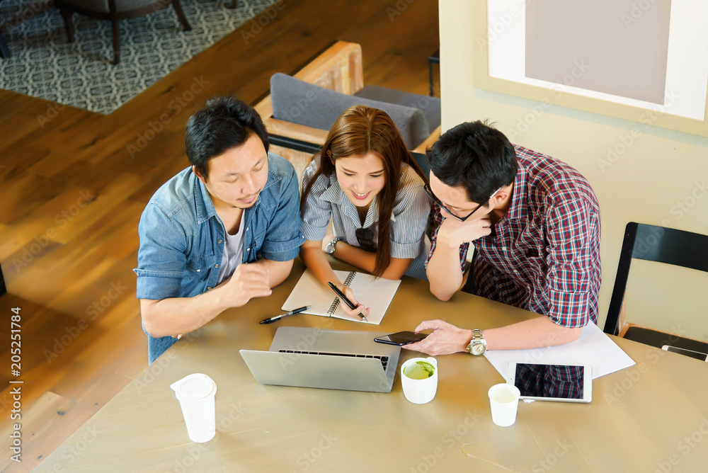 Asian Team group freelancers or students in casual suit are brainstorming and meeting at coffee shop cafe. Business and Office Concept. Asian Team group freelancers or students in casual suit are brainstorming and meeting at coffee shop cafe. Business and Office Concept.