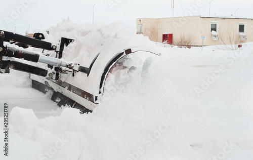 Snow plow cleaning snow from city road
