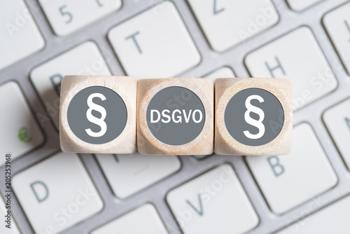 Würfel mit Paragraph Symbolen und Abkürzung DSGVO auf einer Tastatur