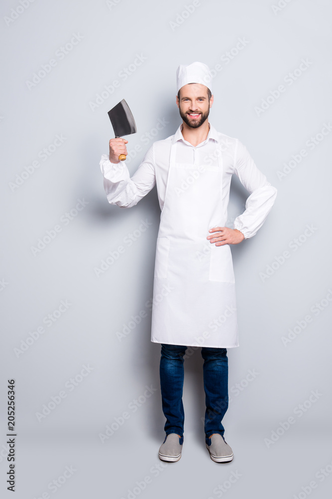 Full size fullbody portrait of positive cheerful butcher in beret having cleaver in arm holding hand on waist, looking at camera, isolated on grey background Full size fullbody portrait of positive cheerful butcher in beret having cleaver in arm holding hand on waist, looking at camera, isolated on grey background