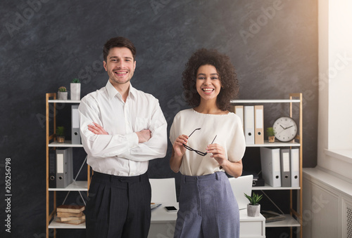 Cheerful business couple standing in office