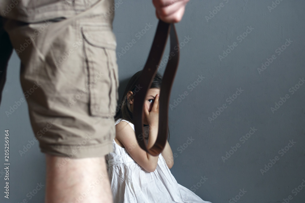 A man with a belt in his hand is going to punish a little girl