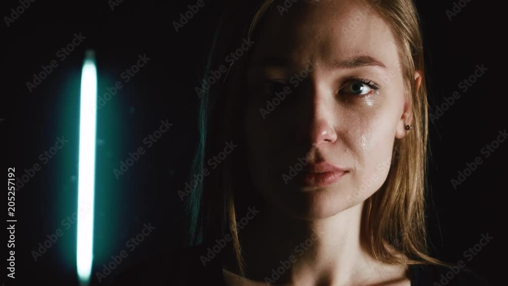 A woman is crying in the dark. Tears of a beautiful girl. 4k
