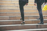 Business and success concept.Persons Back view walking toward successful after meeting.Legs of Engineer and Businesswoman Walk up stair way together to progress work in office.