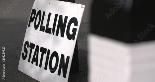 4k slow motion focus pull to polling station sign on election day photo