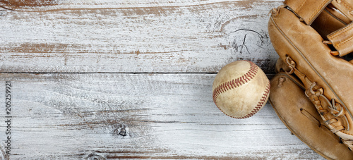 Flat lay view of old baseball and mitt on white rustic wooden boards