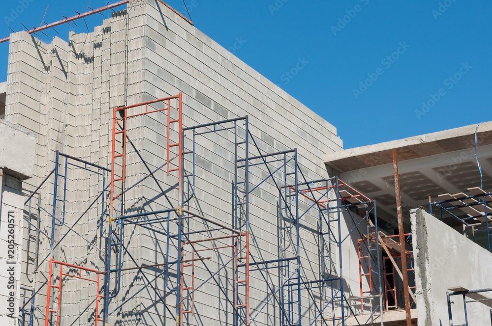 Building in construction area with scaffold and steel bars