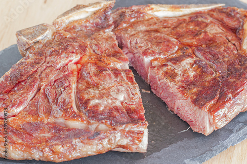 A cut steak on a slate dish.