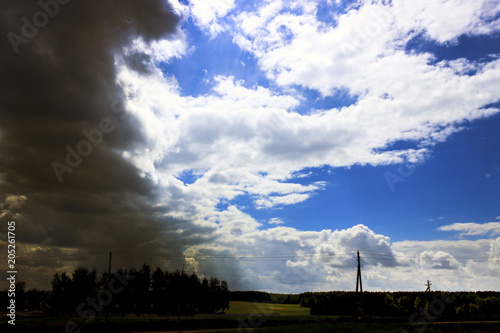 Near the village. Storm. The sky meets a thunderstorm. The sun shines through the clouds