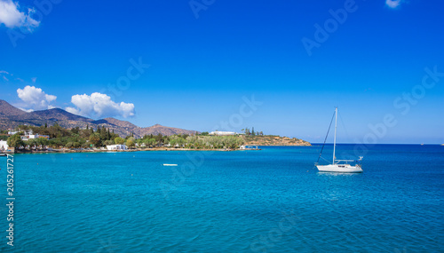 Small natural harbor with anchored sailing boat, Agios Nikolaos, Crete, Greece.