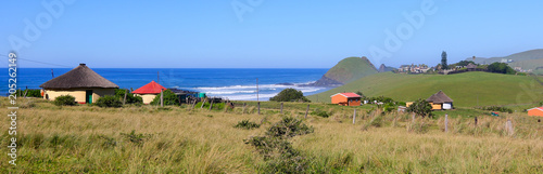 Panoramic view of a rondawel, traditional thatched roofed hut near Coffee Bay on the Wild Coast in Eastern Cape, South Africa, with a view over the Indian Ocean photo
