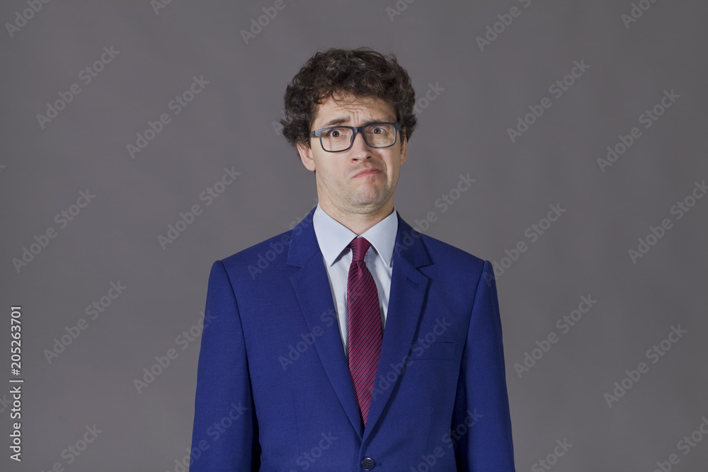 Young man in blue jacket grimacing Young man in blue jacket grimacing