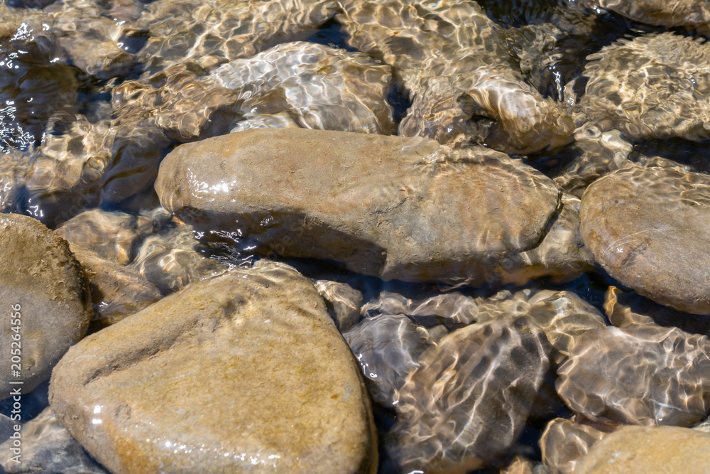 Steine im Wasser am Sonnenlicht