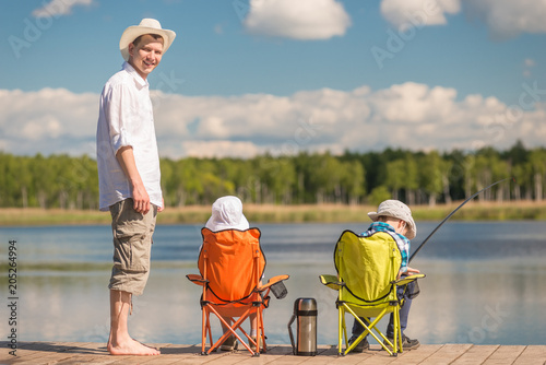 man and two sons on fishing, father teaches children to fish
