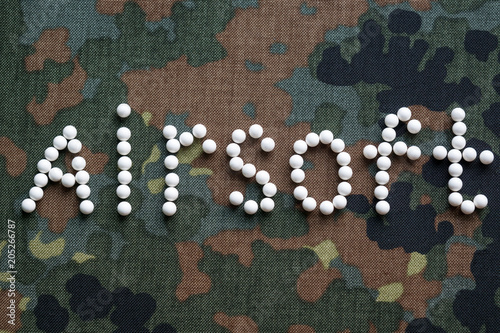 inscription airsoft plastic balls bbs on camouflage fabric photo