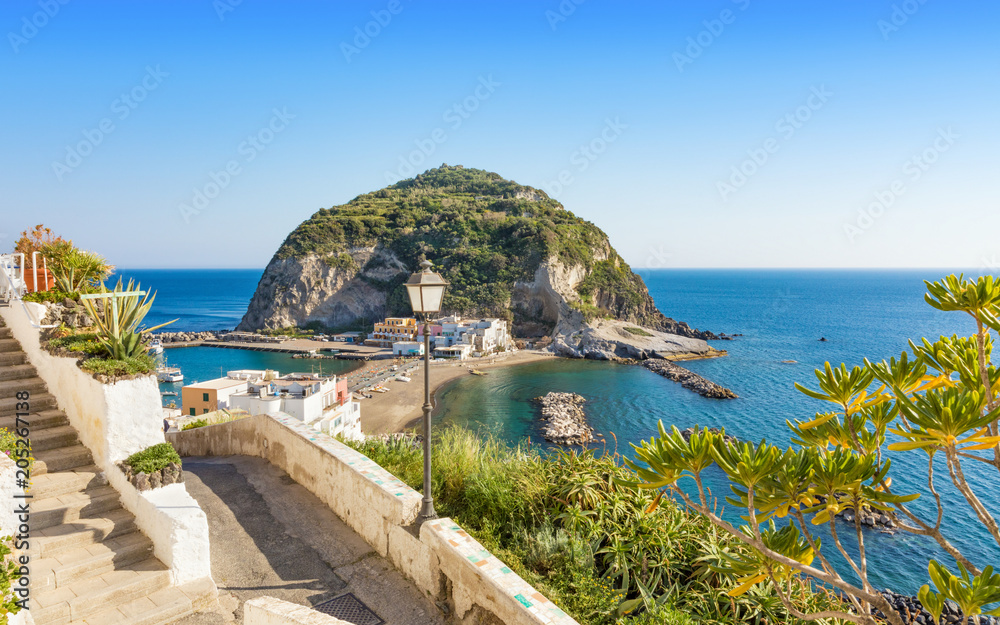 Giant rock with green trees on top near small village Sant'Angelo on Ischia island, region Campania in Italy
