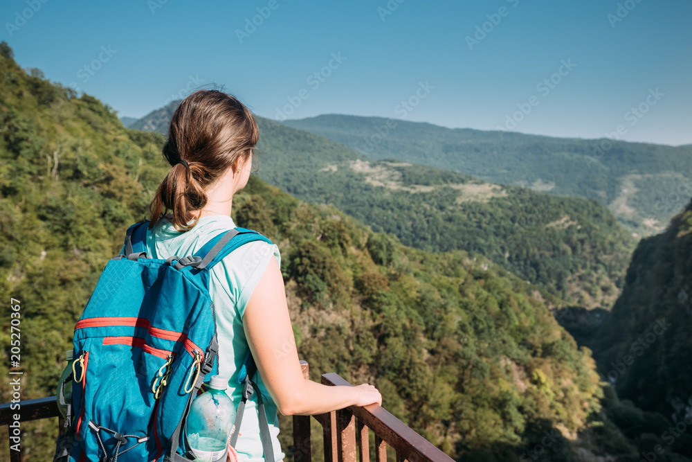 Naklejka premium Zeda-gordi, Georgia. Back View Of Woman Standing On Narrow Suspension Bridge Or Pendant Road Up To 140 Meters Above Precipice