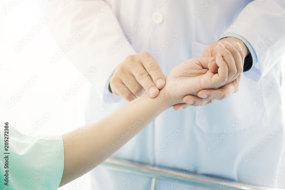 Doctor with patient. Routine health check and holding hands. Male medical doctor with young chinese woman. Doctor with patient. Routine health check and holding hands. Male medical doctor with young chinese woman.