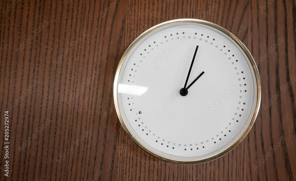 Modern white and gold clock on wooden background Modern white and gold clock on wooden background