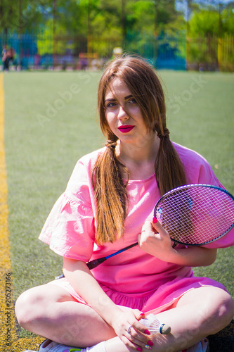 Girl playing badminton on the soccer field on a sunny day