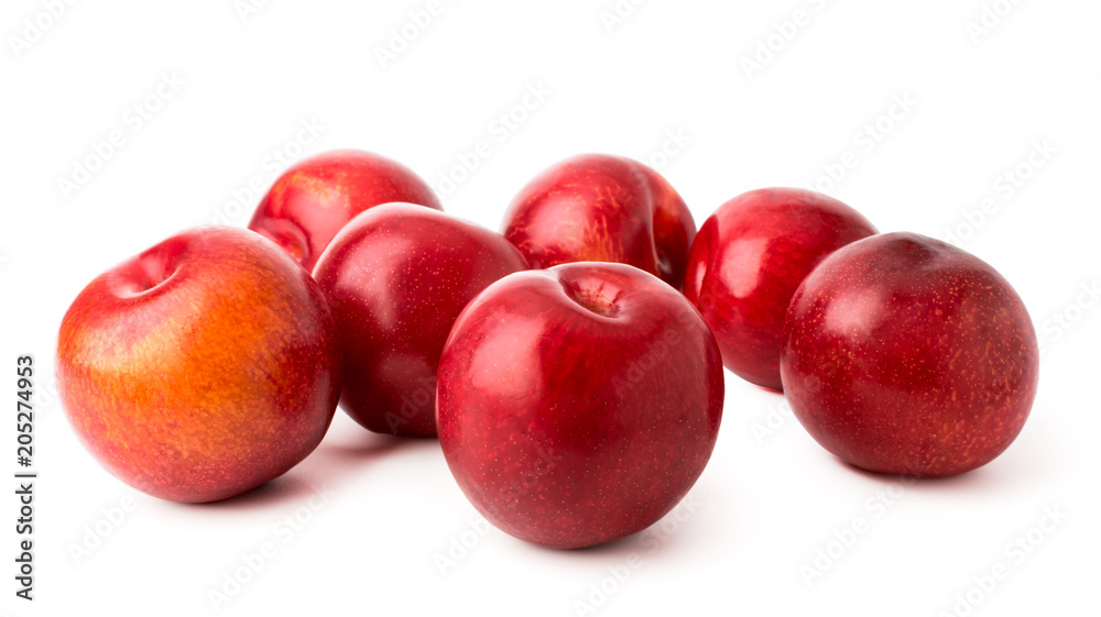 Ripe plums scattered on a white background