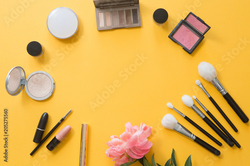 Flat lay and top view of make up products on yellow summer background with copyspace. Beauty concept for blogger, pastel women business office table desk photo