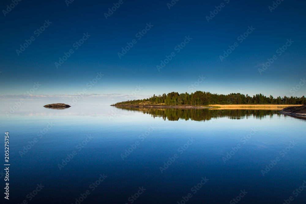Reflection of the island in the water. Karelia. Wild nature of Finland.