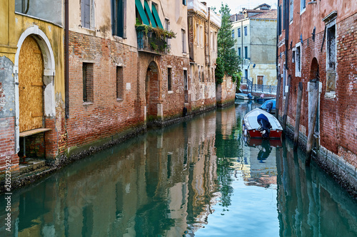 Traditional narrow canal with boats in Venice, Italy