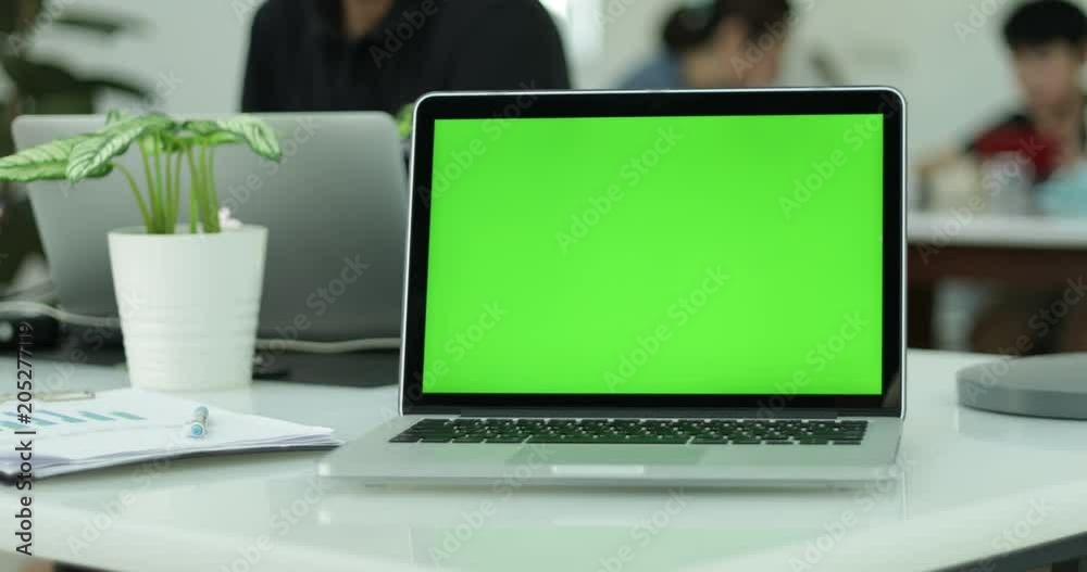 Green laptop computer screen set in front of workgroup