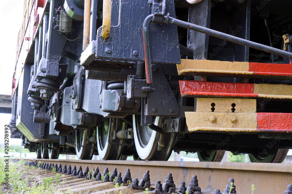 Naklejka premium The wheels of the diesel locomotive on the rails. Railway transport.